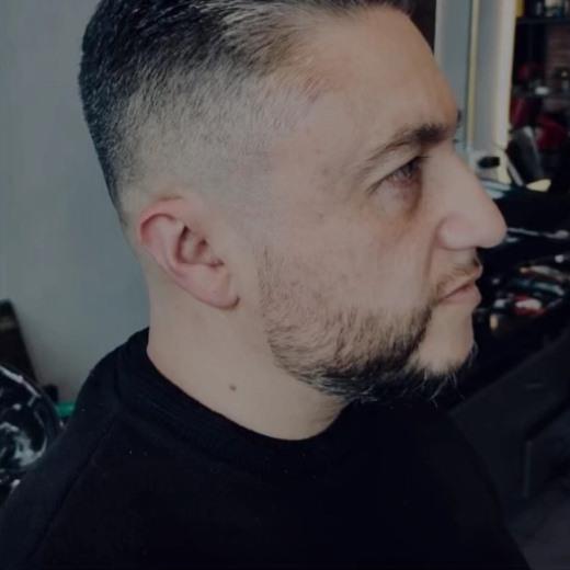 Perfil de un cliente con barba perfilada y degradado