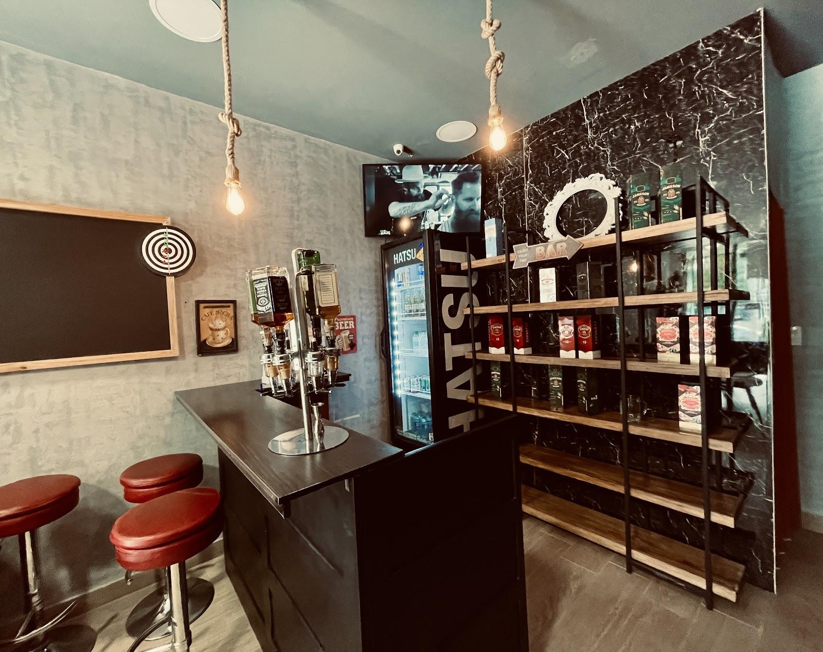 La barra de la barbería con sillas altas y estantes de productos