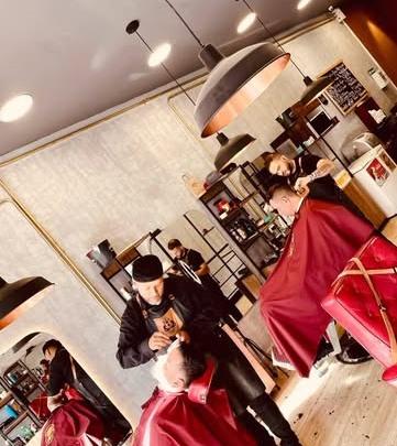 Barberos trabajando en el salón visto desde lo alto
